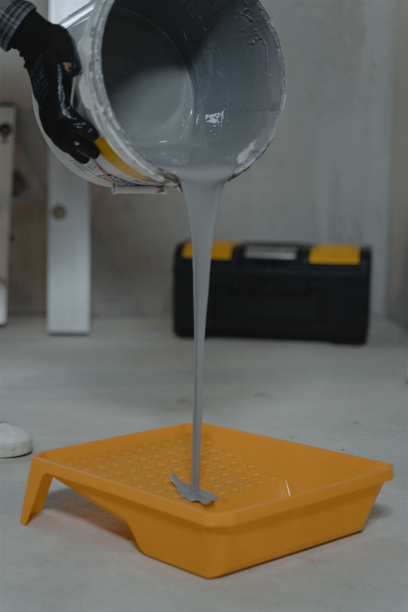 Farbe wird in eine gelbe Farbwanne gegossen