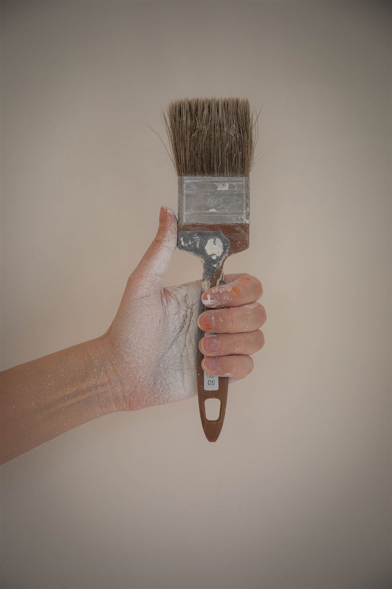 Hand hält einen Malerpinsel