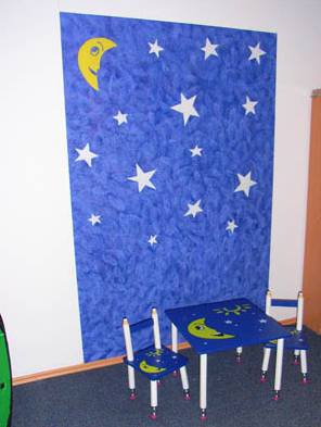 Blaue Kinderzimmerwand mit gemalten Sternen und Mond, passend zu den Kindermöbeln