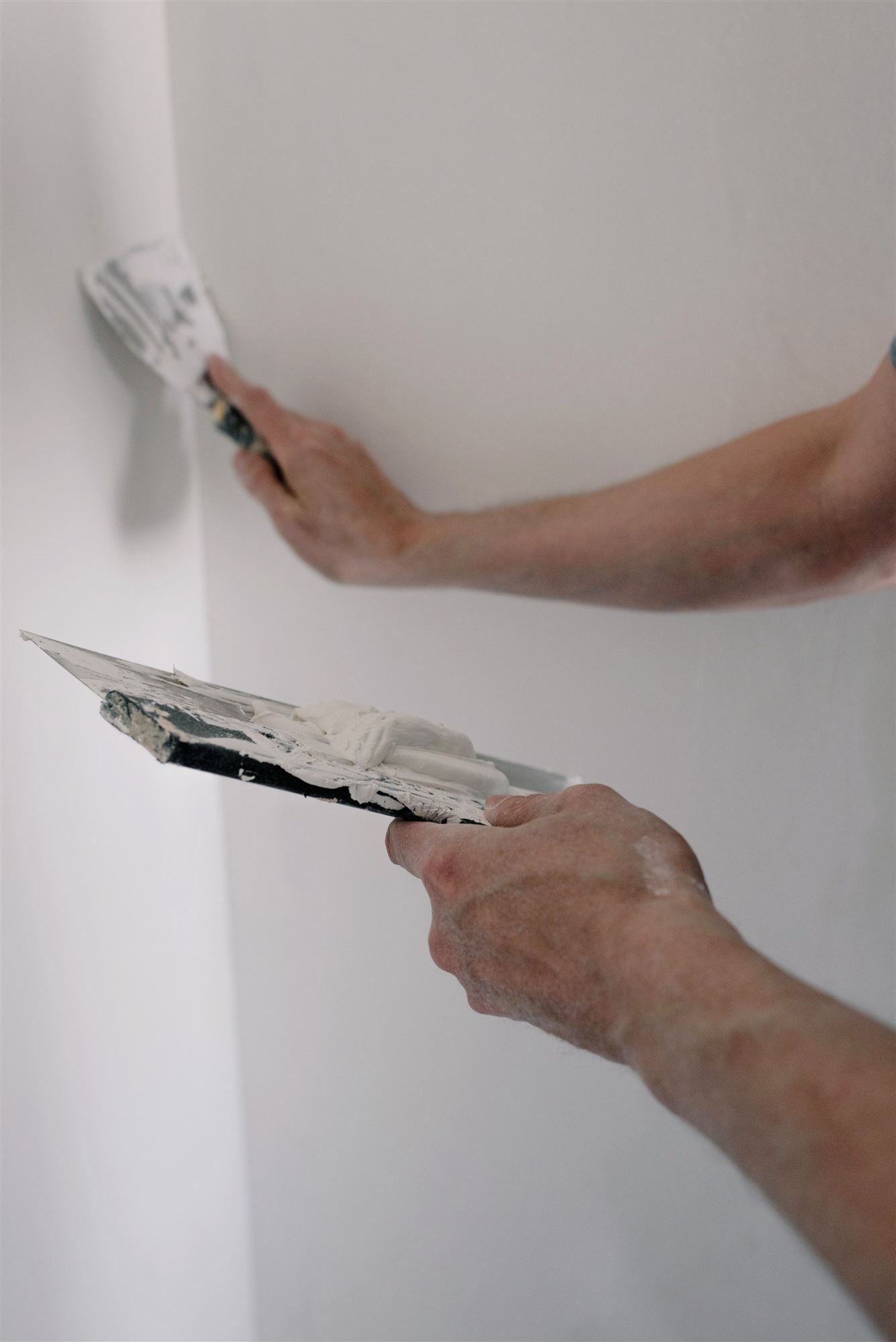 Wand wird mit dem Spachtel sorgfältig geglättet
