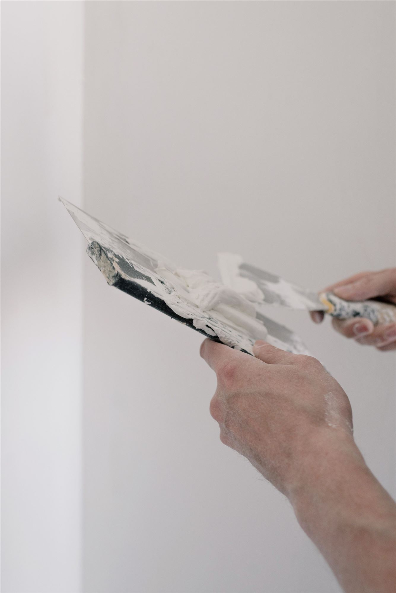 Wand wird mit dem Spachtel für die Sanierung vorbereitet
